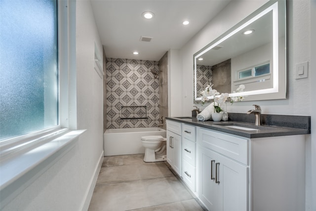 full bathroom with tiled shower / bath, vanity, toilet, and tile patterned floors