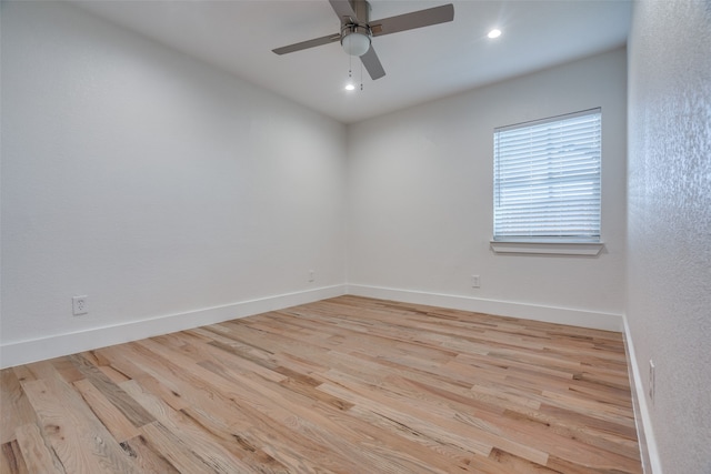 empty room with ceiling fan and light hardwood / wood-style flooring