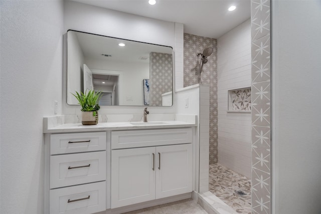 bathroom featuring a tile shower and vanity