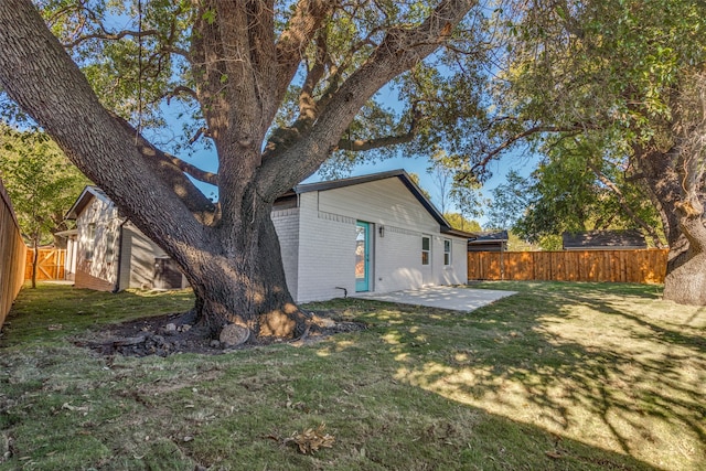 rear view of property with a yard and a patio area