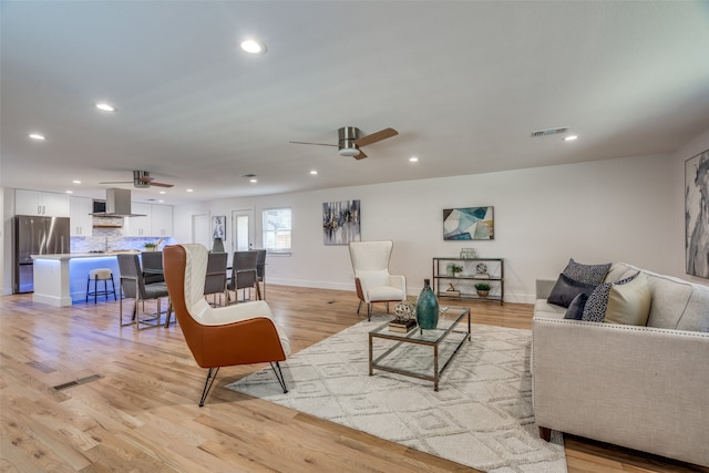 living room with ceiling fan and light hardwood / wood-style floors