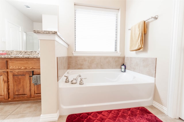 bathroom with tile patterned flooring, vanity, and a washtub