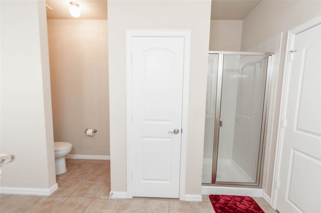 bathroom with toilet, tile patterned floors, and walk in shower