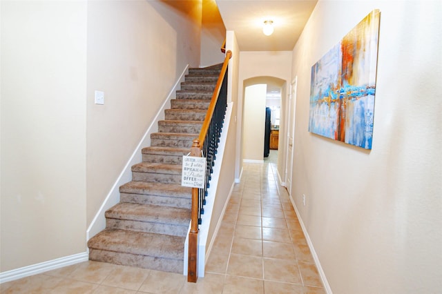 staircase featuring tile patterned flooring