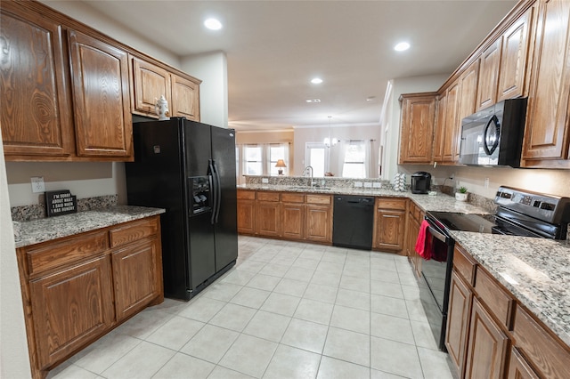 kitchen featuring sink, light stone counters, a notable chandelier, black appliances, and ornamental molding