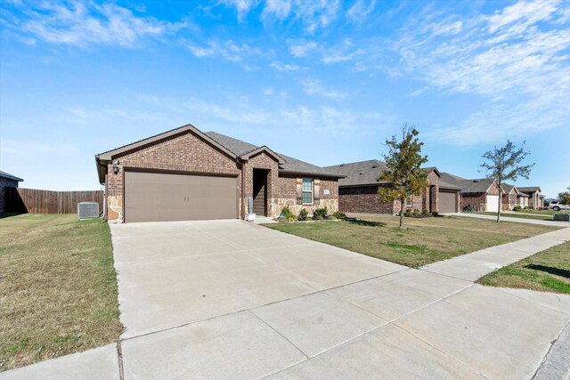 view of front of home with central AC unit, a garage, and a front yard