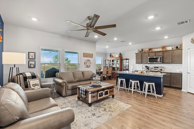 living room with light wood-type flooring and ceiling fan