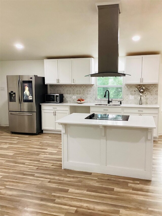 kitchen featuring island exhaust hood, appliances with stainless steel finishes, white cabinets, and sink