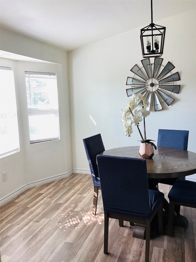 dining space featuring light hardwood / wood-style floors and a notable chandelier