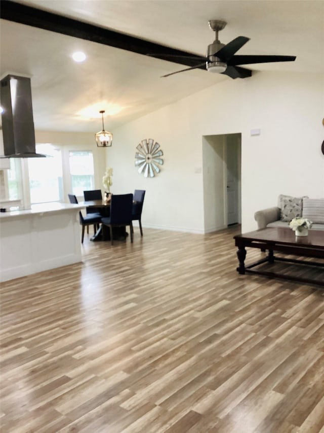 living room featuring ceiling fan with notable chandelier and light hardwood / wood-style floors