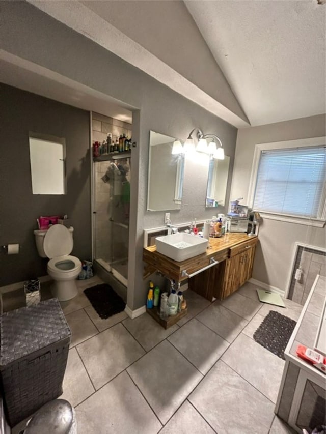 bathroom featuring toilet, tile patterned floors, vaulted ceiling, and sink