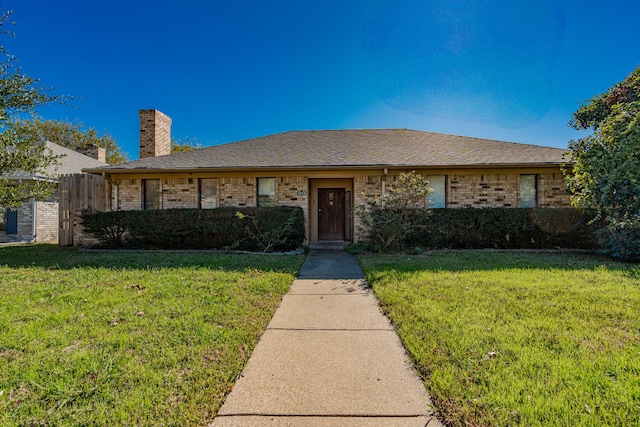 ranch-style home with brick siding, a chimney, a front lawn, and fence