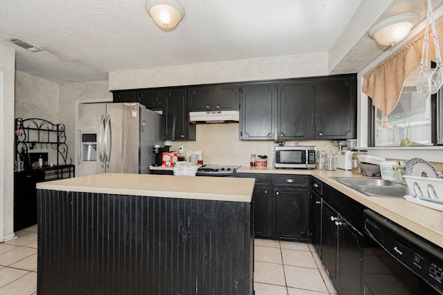 kitchen with visible vents, under cabinet range hood, a sink, dark cabinetry, and stainless steel appliances