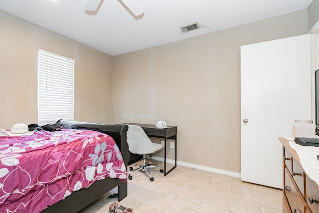 bedroom with ceiling fan and a textured ceiling