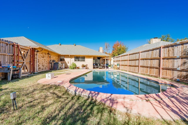 view of pool with a patio area, a lawn, a fenced backyard, and a fenced in pool