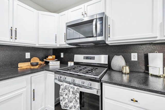 kitchen featuring appliances with stainless steel finishes, backsplash, and white cabinetry