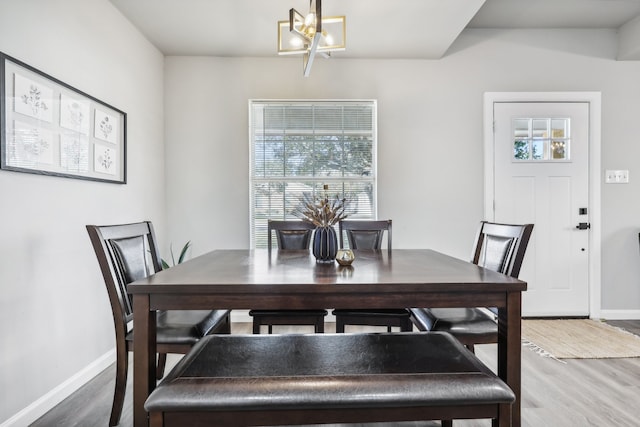 dining area with hardwood / wood-style flooring and a chandelier