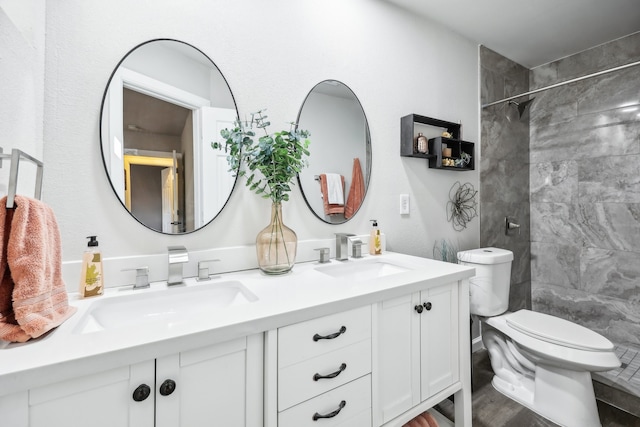 bathroom with vanity, toilet, wood-type flooring, and a tile shower