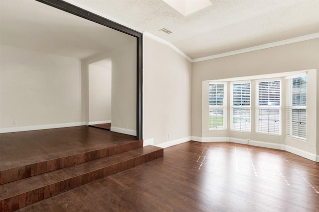 spare room with wood-type flooring, a textured ceiling, and crown molding