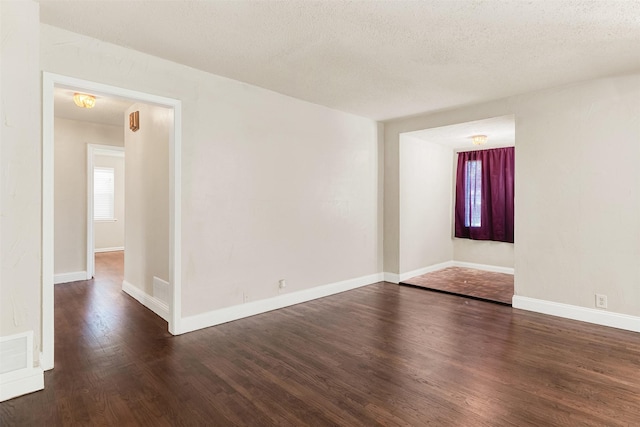 1725 Brake Dr, Carrollton, TX 75006 - unfurnished room with dark wood finished floors and a textured ceiling