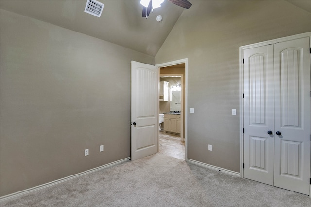 unfurnished bedroom with a closet, light colored carpet, high vaulted ceiling, and ceiling fan