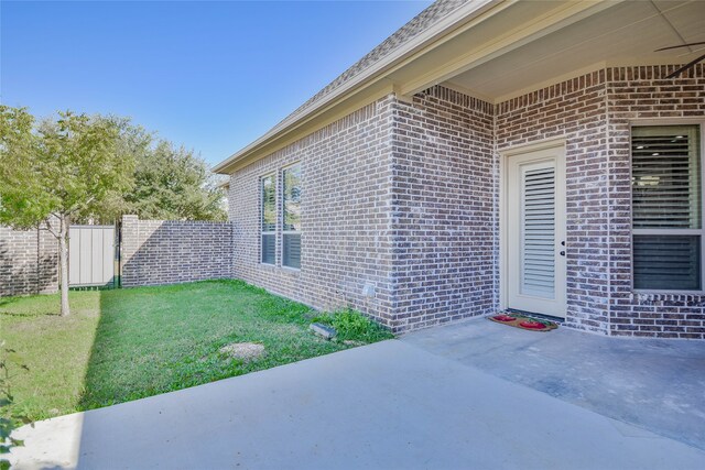 entrance to property with a lawn and a patio