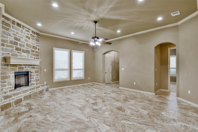 unfurnished living room featuring a stone fireplace, crown molding, and ceiling fan