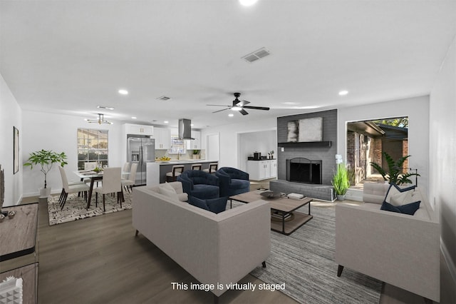 living room with a brick fireplace, hardwood / wood-style floors, and ceiling fan