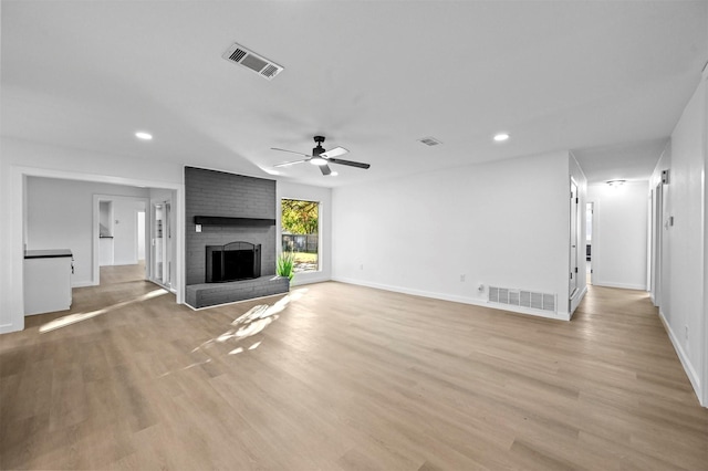 unfurnished living room with light hardwood / wood-style flooring, a fireplace, and ceiling fan