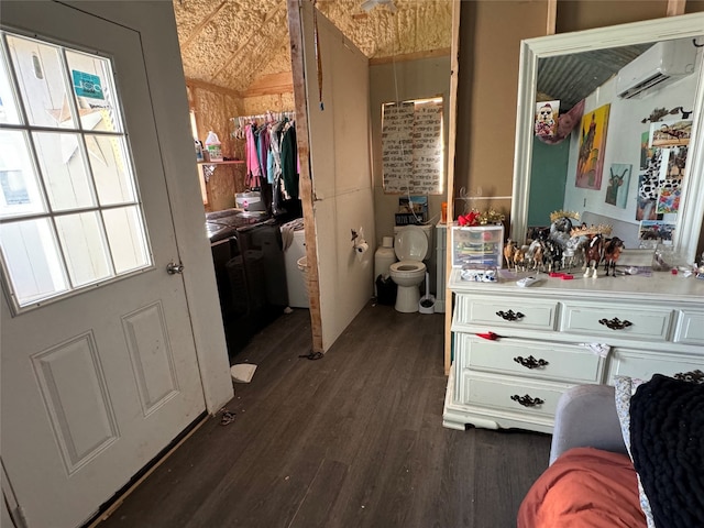 bathroom with an AC wall unit, hardwood / wood-style floors, lofted ceiling, and toilet