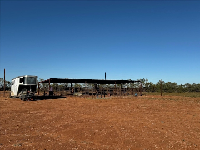 view of yard with an outbuilding, a rural view, and an exterior structure