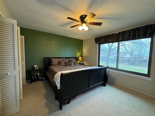 carpeted bedroom featuring a textured ceiling, ceiling fan, and a closet