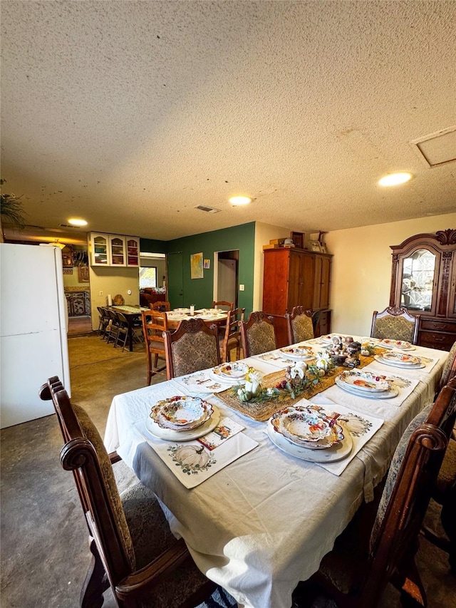 dining space with a textured ceiling and concrete floors