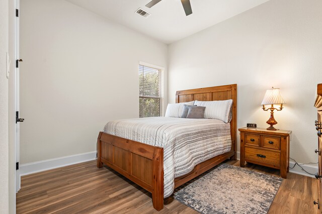 bedroom with dark hardwood / wood-style floors and ceiling fan