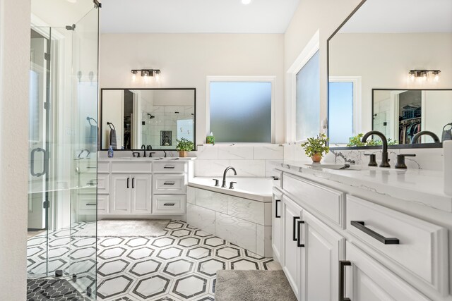 bathroom featuring plus walk in shower, vanity, and tile patterned flooring