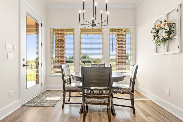 dining room featuring light hardwood / wood-style floors, ornamental molding, and an inviting chandelier