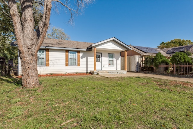 ranch-style home with solar panels, a porch, and a front lawn