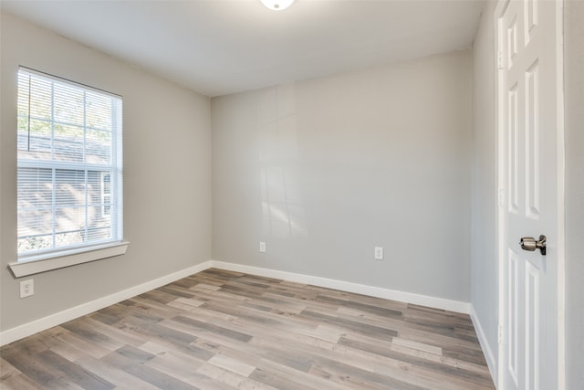 empty room with plenty of natural light and light hardwood / wood-style flooring