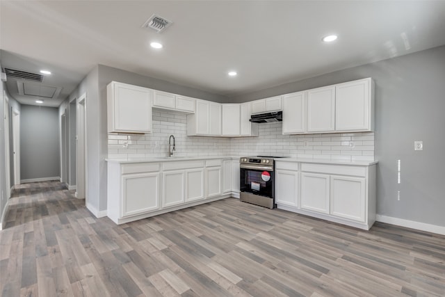 kitchen with sink, light hardwood / wood-style flooring, stainless steel range with electric cooktop, backsplash, and white cabinets