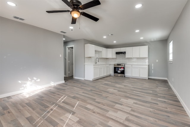 unfurnished living room featuring light hardwood / wood-style floors, ceiling fan, and sink