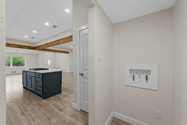 kitchen with kitchen peninsula, light hardwood / wood-style floors, and stainless steel gas stovetop