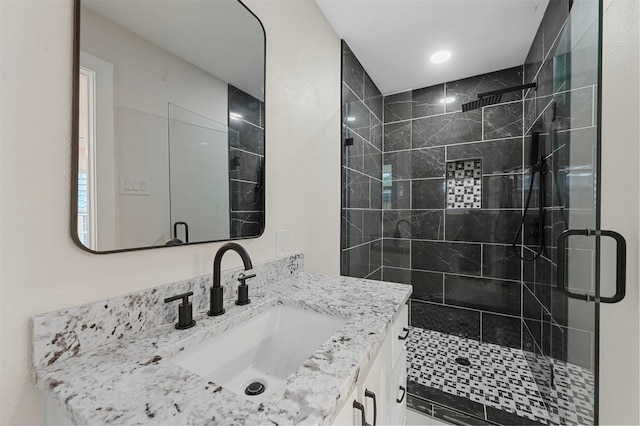 bathroom with vanity and a shower with door