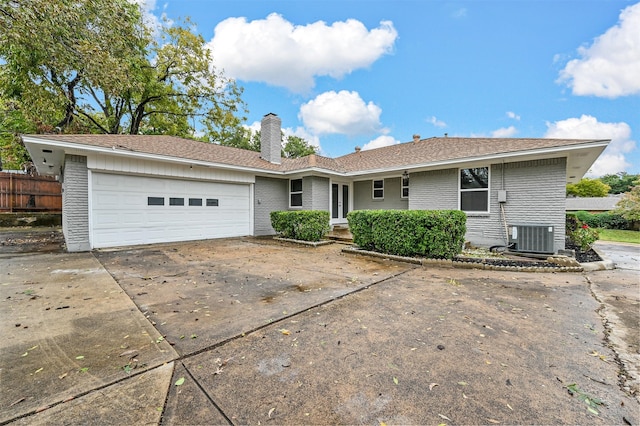 ranch-style house featuring central AC and a garage