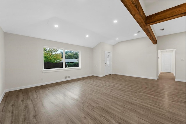 unfurnished living room with wood-type flooring and lofted ceiling with beams