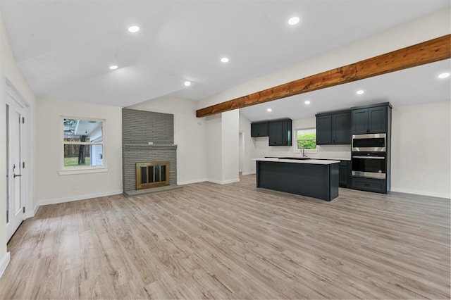 kitchen featuring a wealth of natural light, a center island, light hardwood / wood-style floors, and appliances with stainless steel finishes