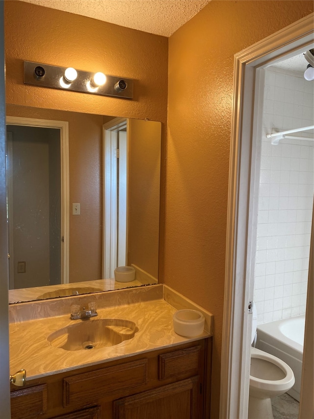 bathroom with vanity, a textured ceiling, and toilet