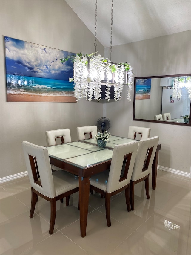 tiled dining area featuring vaulted ceiling