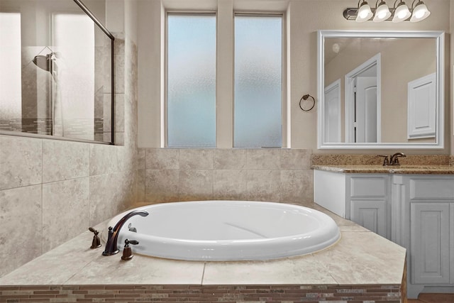 bathroom featuring a tub to relax in and vanity