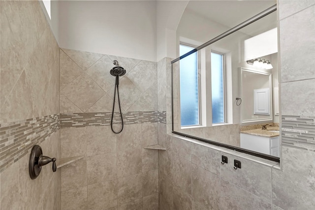 bathroom featuring a tile shower and vanity