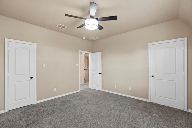 unfurnished bedroom with ceiling fan, dark carpet, and vaulted ceiling